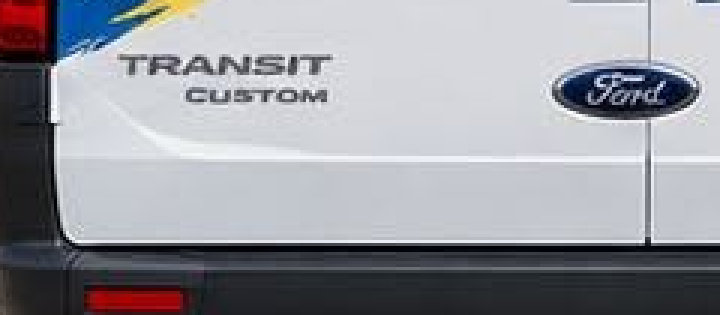 Detail zadnej časti dodávky s nápisom TRANSIT